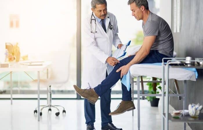Man dealing with a pre-existing injury visits doctor after workers' compensation accident