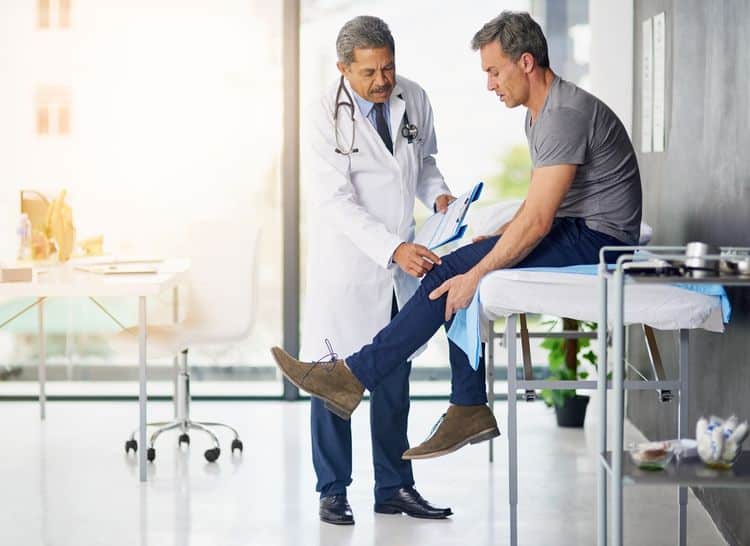Man dealing with a pre-existing injury visits doctor after workers' compensation accident
