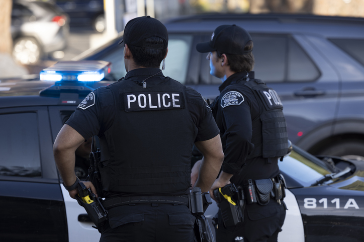 Two police officers observing an accident scene - Do you have to call the police for a car accident?
