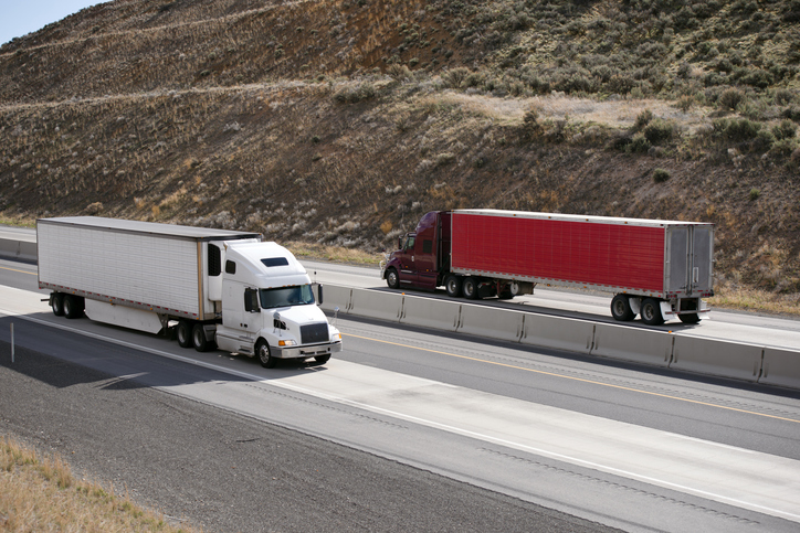 two trucks passing by on a highway - Can more than one party be responsible in truck accidents?