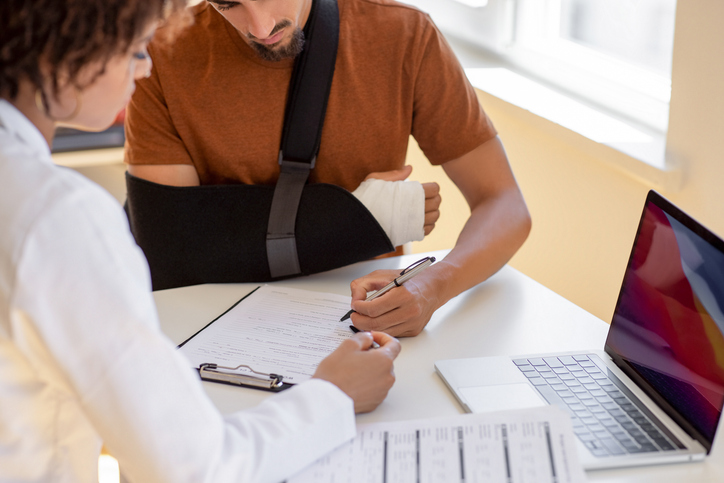 man with injured arm signing a document - Can I claim personal injury if it was my fault?